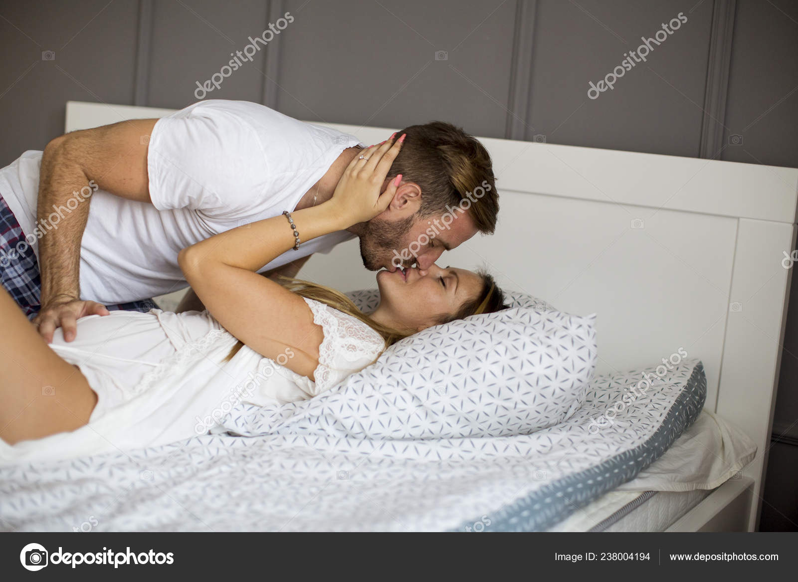 Поцелуи пары в комнате на кровате